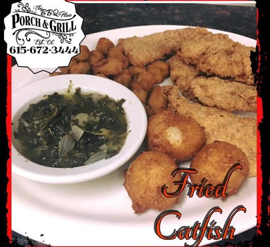 A fried catfish plate with hushpuppies and a bowl of greens